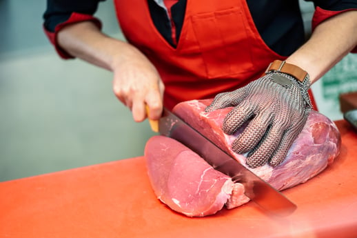 woman-cutting-fresh-meat-in-a-butcher-shop-with-metal-safety-mesh-glove-1